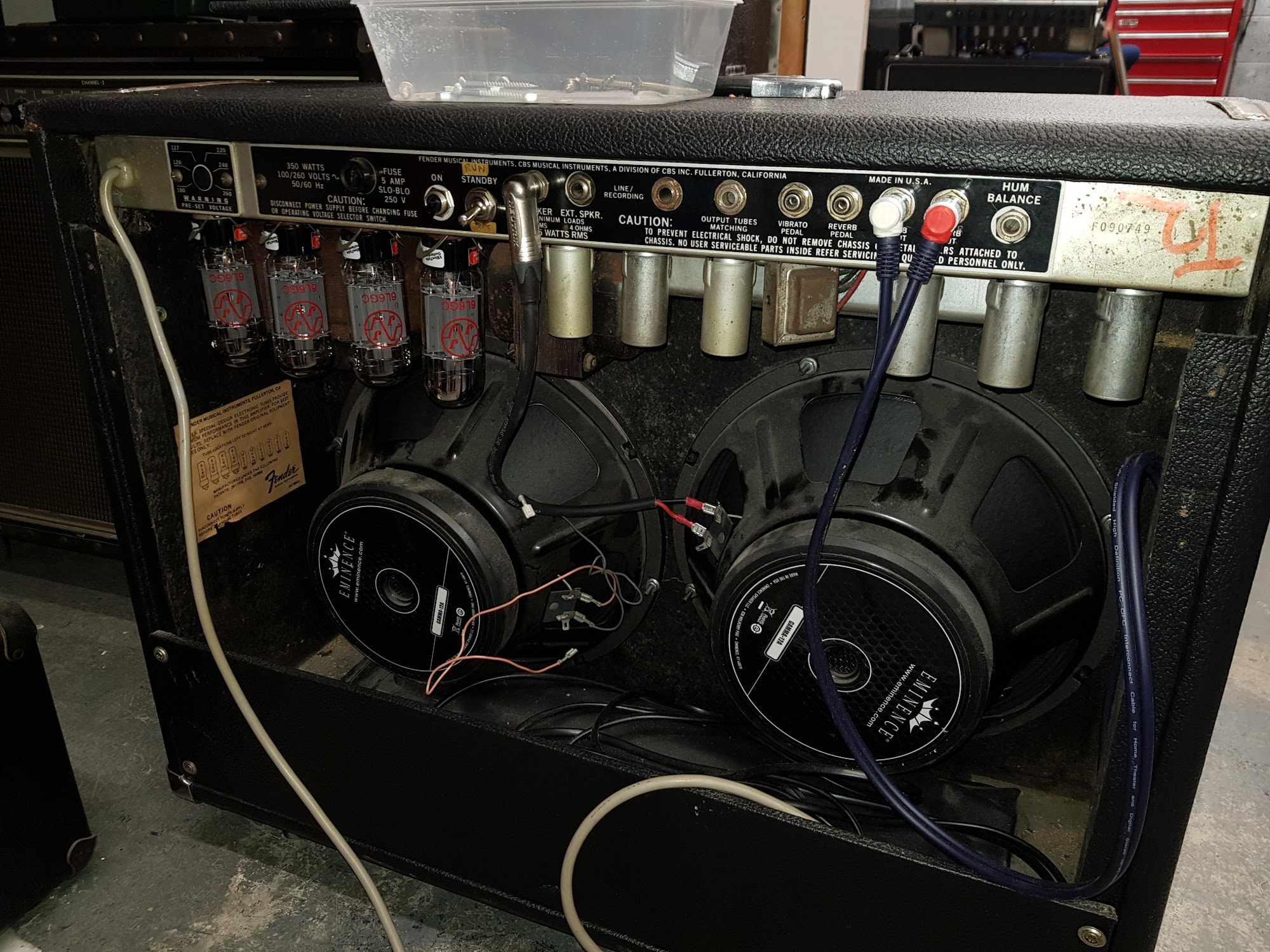 Rear of a Fender Twin Reverb with the back panel removed, showing the chassis, valves and two 12 inch speakers